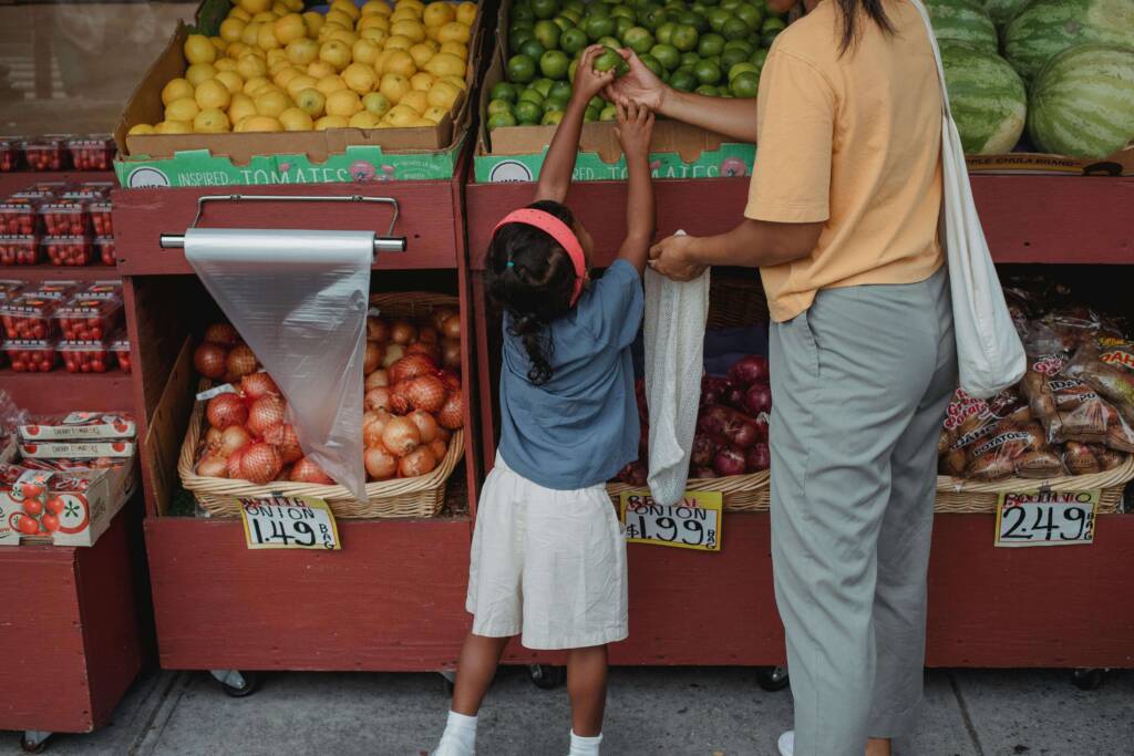Single mother on alimony shopping for fruits with her daughter