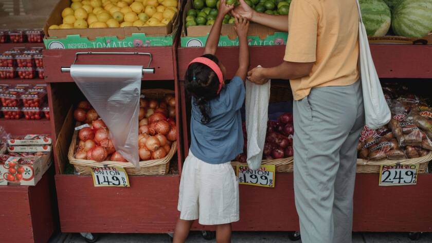Single mother on alimony shopping for fruits with her daughter