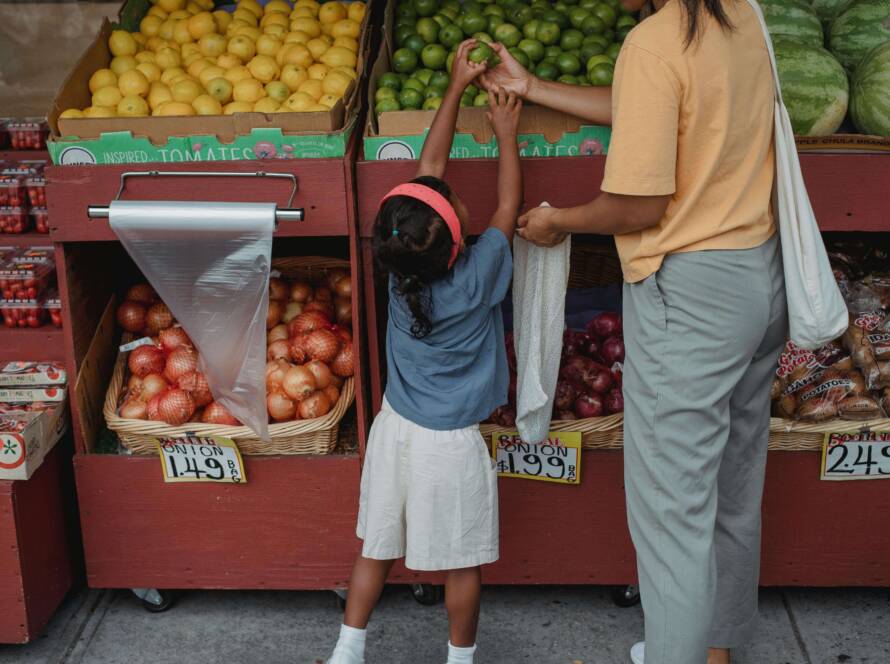 Single mother on alimony shopping for fruits with her daughter
